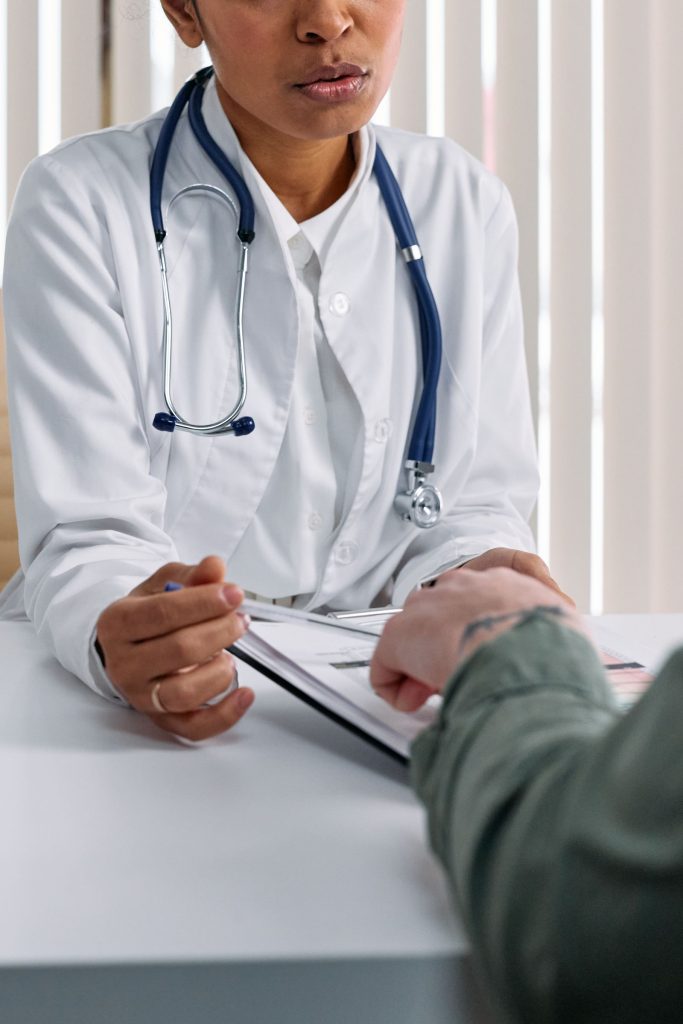A physician and a patient review a printed document together at a table